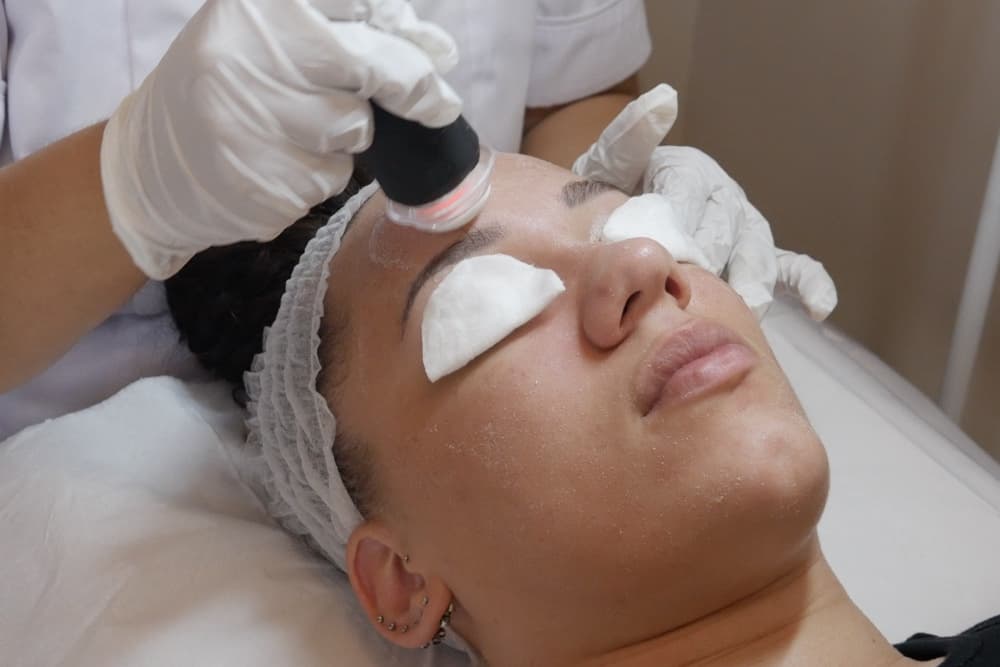A practitioner performing a facial treatment